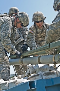 U.S. Army Reserve Soldiers with the 364th Engineer Company (Sapper) load the rocket of an M58 Mine Clearing Line Charge, a rocket-projected line charge usually used to clear mines, during River Assault at Fort Chaffee, Ark., July 29. (U.S. Army photo by Staff Sgt. Roger Ashley)