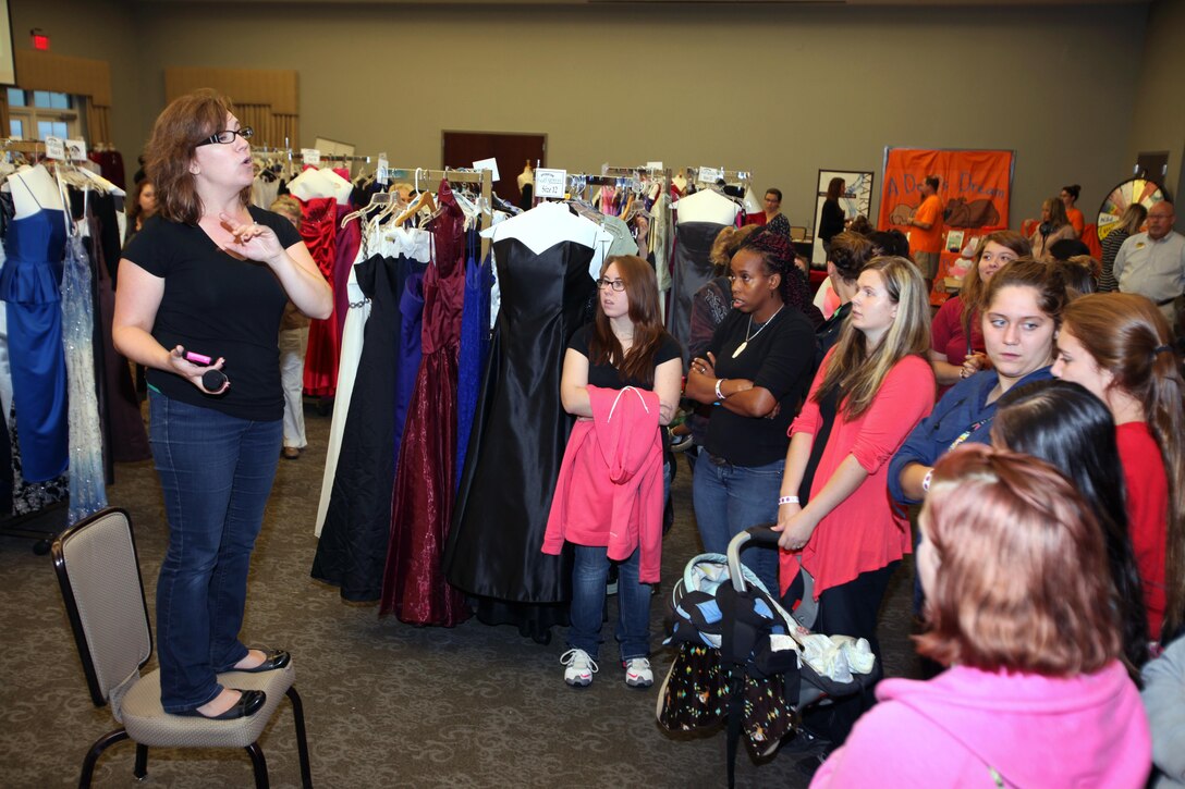 Jocelyn Jakubowski instructs participants on the process for selecting a gown during Operation Ball Gown at Marine Corps Air Station Cherry Point, N.C., Oct. 2, 2015 More than 100 women celebrated the 7th annual Operation Ball Gown with Marine Corps Ball etiquette tips and the opportunity to select a free gown. They were given a sneak-peak into the birthday ball ceremony where they learned the ins-and-outs of the historical tradition while waiting for their opportunity to select a gown. Jakubowski is the director of Marine Corps Family Team Building. (U.S. Marine Corps photo by Lance Cpl. Jason Jimenez/Released)