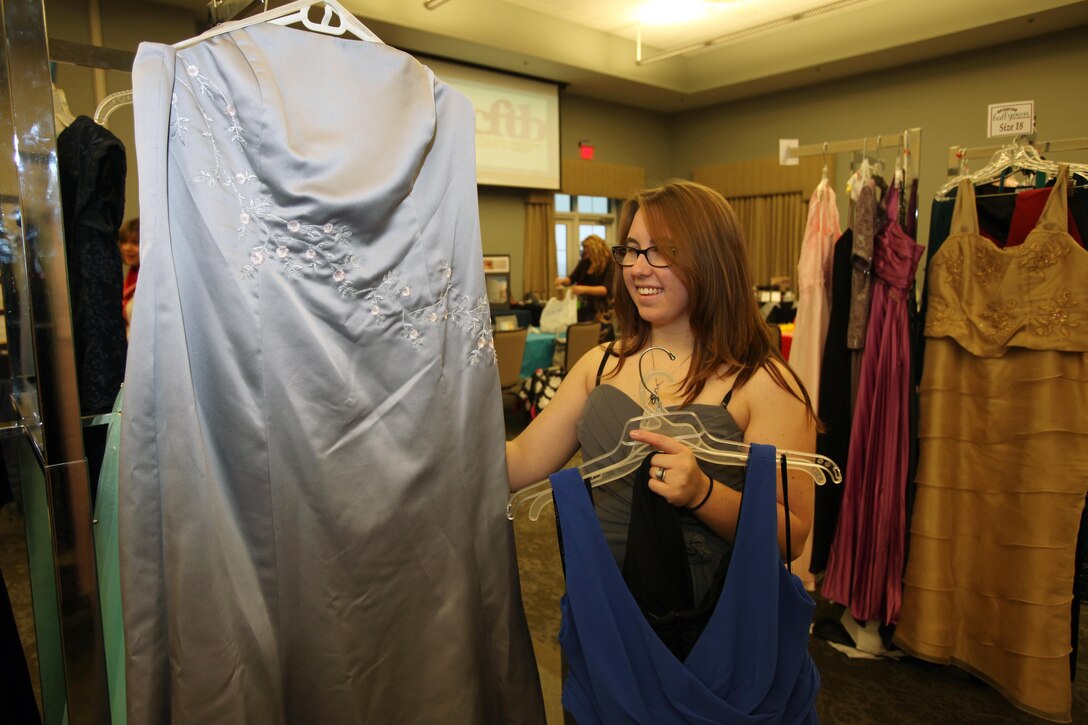 Rachel Jones selects a gown during Operation Ball Gown at Marine Corps Air Station Cherry Point, N.C., Oct. 2, 2015. More than 100 women celebrated the 7th annual Operation Ball Gown with Marine Corps Ball etiquette tips and the opportunity to select a free gown. They were given a sneak-peak into the birthday ball ceremony where they learned the ins-and-outs of the historical tradition while waiting for their opportunity to select a gown. (U.S. Marine Corps photo by Lance Cpl. Jason Jimenez/Released)