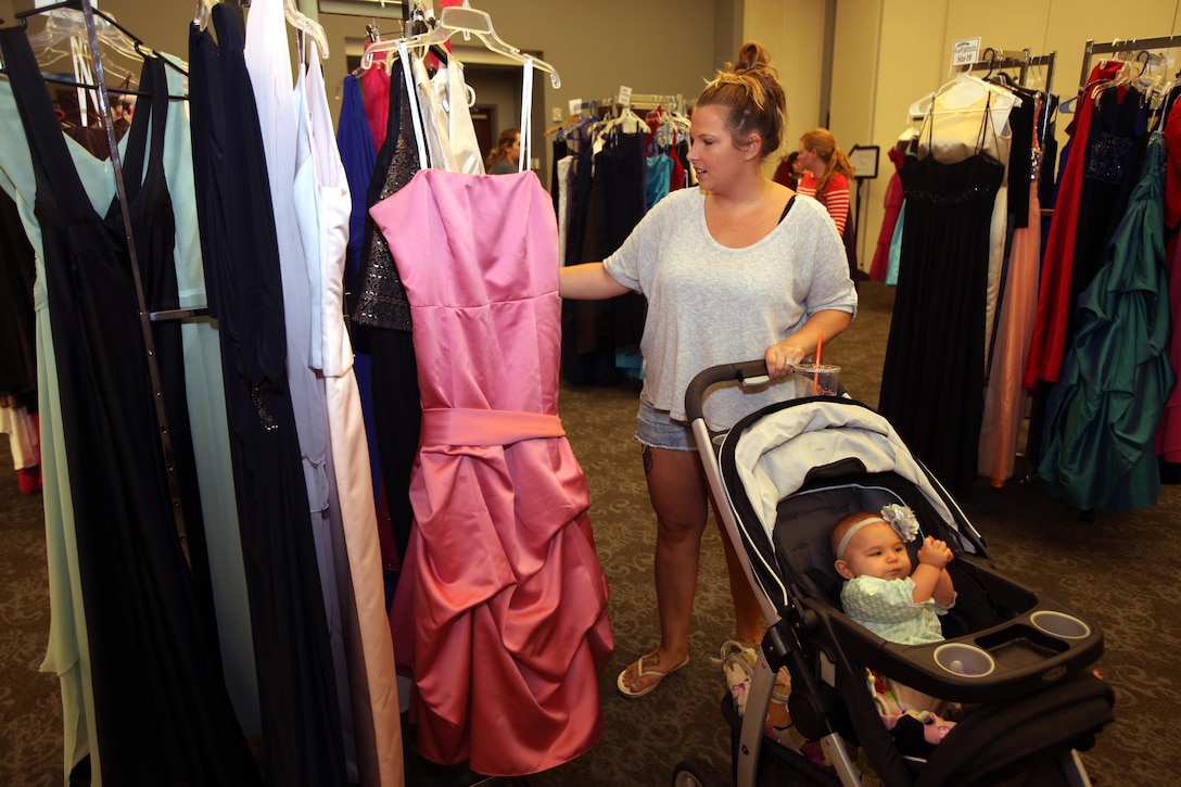 Michelle Walters selects a gown with her baby during Operation Ball Gown at Marine Corps Air Station Cherry Point, N.C., Oct. 2, 2015. More than 100 women celebrated the 7th annual Operation Ball Gown with Marine Corps Ball etiquette tips and the opportunity to select a free gown. They were given a sneak-peak into the birthday ball ceremony where they learned the ins-and-outs of the historical tradition while waiting for their opportunity to select a gown. (U.S. Marine Corps photo by Lance Cpl. Jason Jimenez/Released)