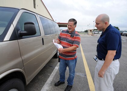 Dennis Jensen, 502nd Logistics Readiness Squadron vehicle dispatcher, helps Emilio Echeverria, Air Force Personnel Operations Agency, inspect a vehicle he is checking out to travel for official business from Joint Base San Antonio-Randolph to JBSA-Fort Sam Houston June 16, 2015. (U.S. Air Force photo by Melissa Peterson)