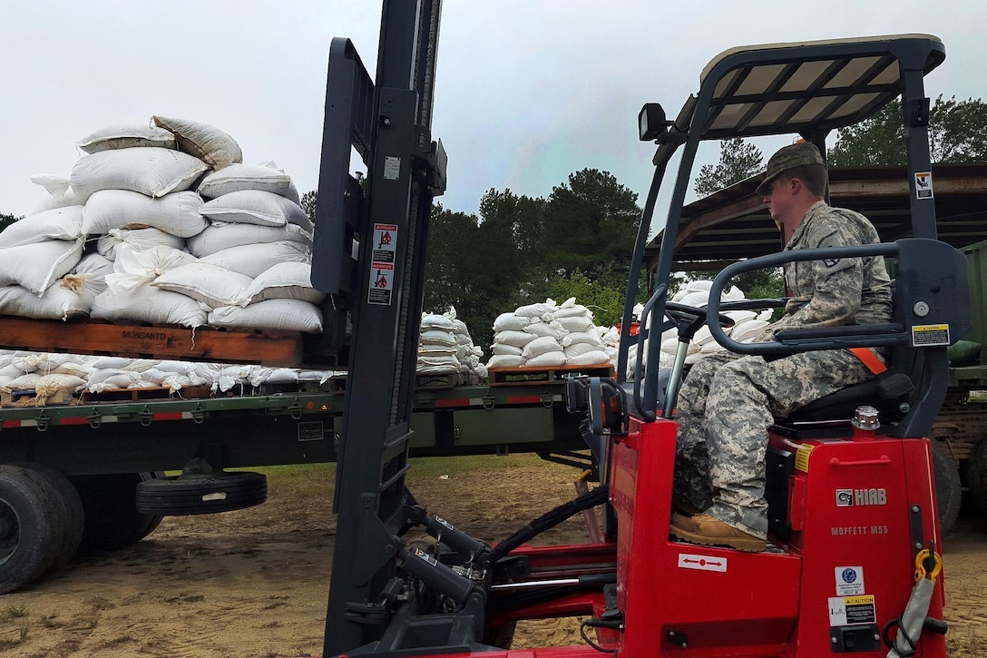 Army Spc. Joshua Monk helps move and deliver sandbags to county emergency managers during flood response in Chesterfield, S.C., Oct. 3, 2015. Monk is a forklift operator assigned to the South Carolina National Guard's 1052nd Transportation Company. State officials projected historic amounts of rainfall for the region after a weather system collided with the outer bands of Hurricane Joaquin. South Carolina National Guard photo by Sgt. David Erskine 