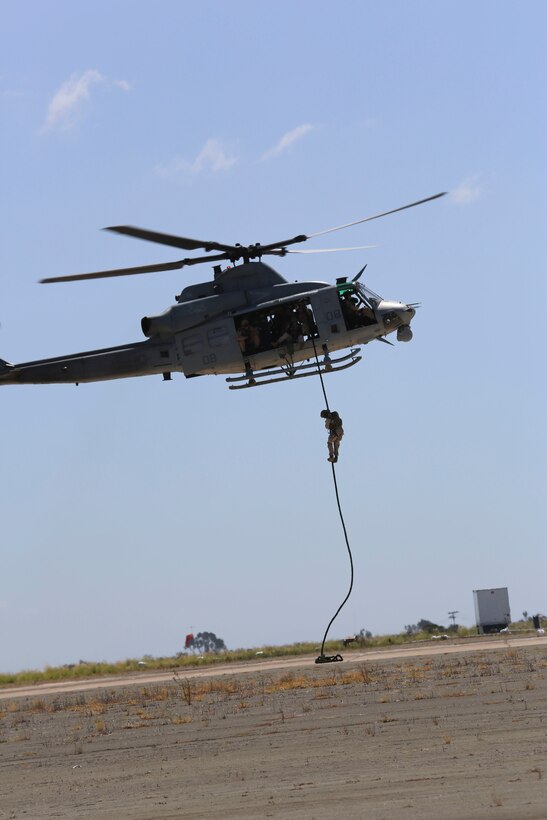 Marines with 1st Marine Division fast rope out of a UH-1Y Huey while demonstrating Marine Air Ground Task Force operations during the 2015 MCAS Miramar Air Show aboard Marine Corps Air Station Miramar, Calif., Oct. 2. This year's air show honored veterans and their families. (U.S. Marine Corps photo by Cpl. Alissa P. Schuning/Released)