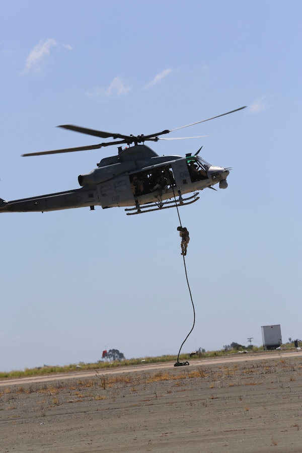 Marines with 1st Marine Division fast rope out of a UH-1Y Huey while demonstrating Marine Air Ground Task Force operations during the 2015 MCAS Miramar Air Show aboard Marine Corps Air Station Miramar, Calif., Oct. 2. This year's air show honored veterans and their families. (U.S. Marine Corps photo by Cpl. Alissa P. Schuning/Released)