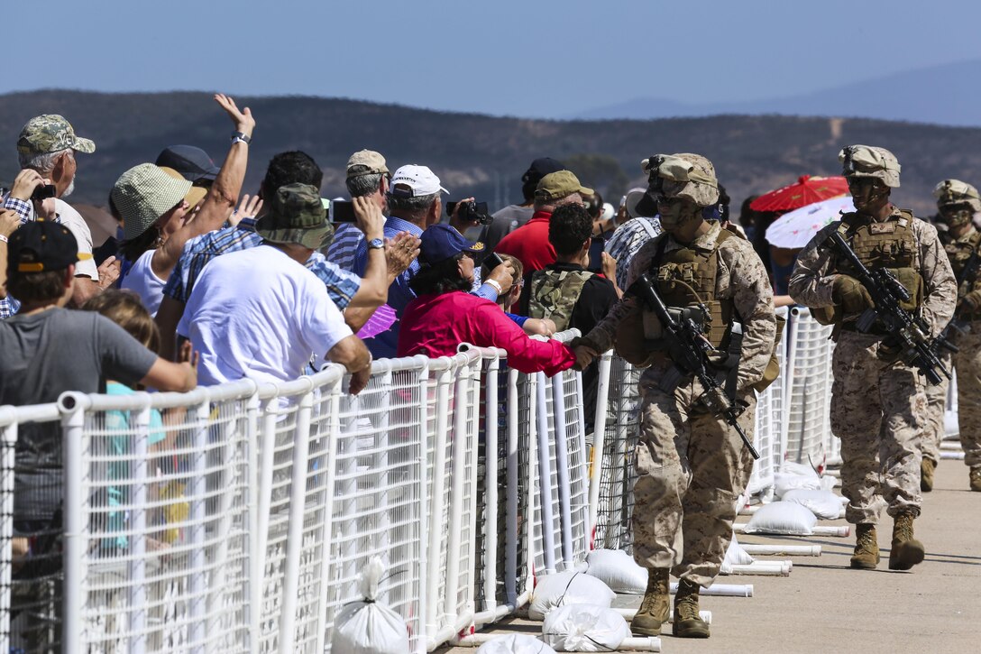 Marines with 1st Marine Division shake hands with audience members during the 2015 MCAS Miramar Air Show’s Marine Air-Ground Task Force demonstration aboard Marine Corps Air Station Miramar, Calif., Oct. 2. The MAGTF demonstration shows the capabilities of several Marine Corps assets. (U.S. Marine Corps photo by Cpl. Alissa P. Schuning/Released)