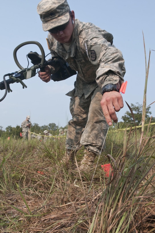 U.S. Army Reserve Spc. Tyler Chatterton, 402nd Engineer Company (Sapper) places a flag on an inert mine on a mine clearing lane during Sapper Stakes 2015 at Fort Chaffee, Ark., Aug. 31. Teams were tested on their ability to find and mark six inert mines. (U.S. Army photo by Staff Sgt. Debralee Best)