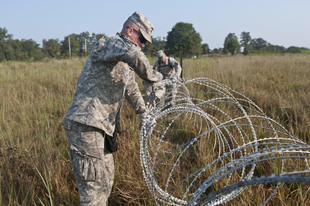 U.S. Army Reserve Soldiers with the 348th Engineer Company, lay concertina wire while emplacing a hasty frat fence during Sapper Stakes 2015 at Fort Chaffee, Ark., Sept. 1. (U.S. Army photo by Staff Sgt. Debralee Best)