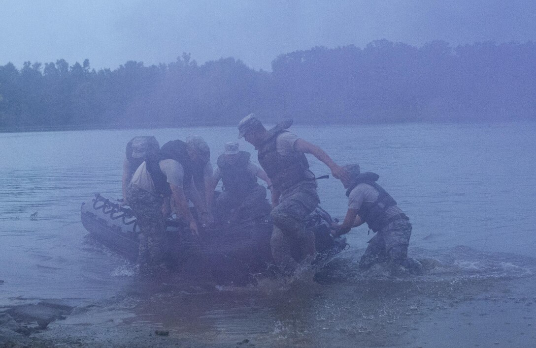 Soldiers competing in Sapper Stakes 2015, disembark a Zodiac boat to pull it onto shore after rowing across Engineer Lake at Fort Chaffee, Ark., as part of the nonstandard Army Physical Fitness Test Aug. 30. (U.S. Army photo by Staff Sgt. Debralee Best)