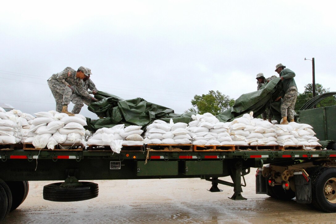 Soldiers cover a truckload of sandbags at the Wateree Correctional Facility in preparation of Hurricane Joaquin in Rembert, S.C., Oct. 3, 2015. South Carolina Army National Guard photo by Sgt. Brad Mincey