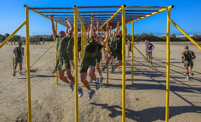 Recruits of Mike Company, 3rd Recruit training Battalion, climb across monkey bars during the Circuit Course at Marine Corps Recruit Depot San Diego, Sept. 29. Recruits were instructed to touch each bar with both of their hands while maneuvering through this portion of the course. Today, all males west of the Mississippi are trained at MCRD San Diego. The depot is responsible for training more than 16,000 recruits annually. Mike Company is scheduled to graduate Dec. 11.