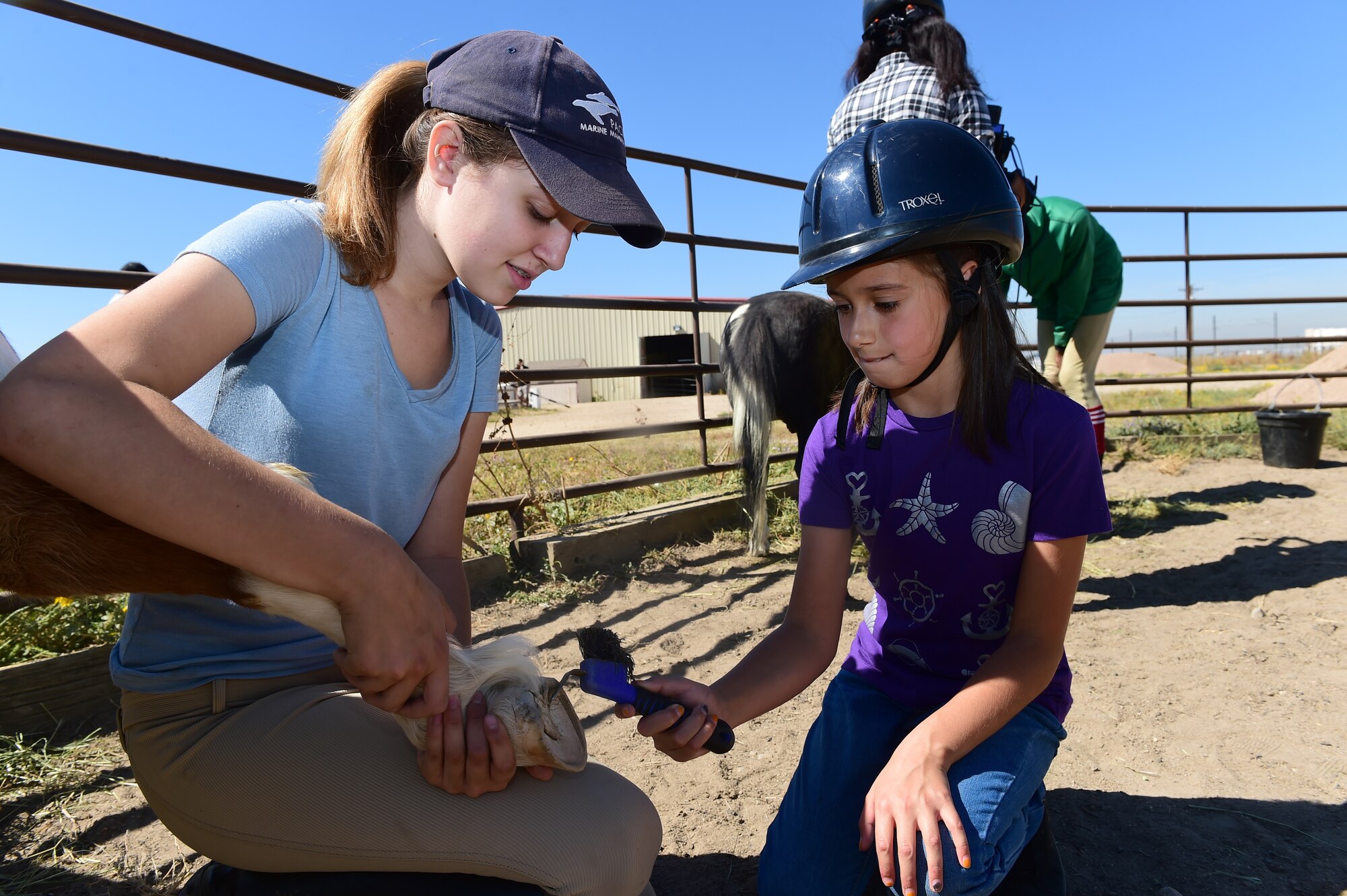 A child from Buckley Air Force Base cleans a horse’s hoof Sept. 26, 2015, at Urban Farm in Stapleton, Colo. Urban Farm hosted Buckley families, providing them with a tour of the farm as well as an opportunity to interact with the animals. (U.S. Air Force photo by Airman 1st Class Luke W. Nowakowski/Released)