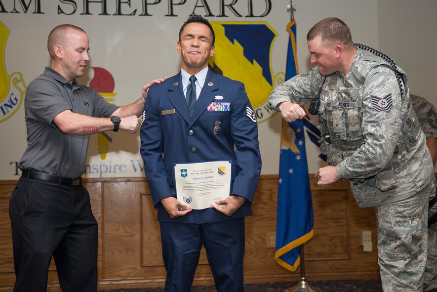 Senior Airman Clifford Quinsay, 82nd Security Forces Squadron defender, has his new staff sergeant stripes tacked on by his colleagues at Sheppard Air Force Base, Texas, Sept. 30, 2015. Quinsay, along with 10 others, participated in the Sheppard Monthly promotion ceremony. (U.S. Air Force photo/Senior Airman Kyle Gese)