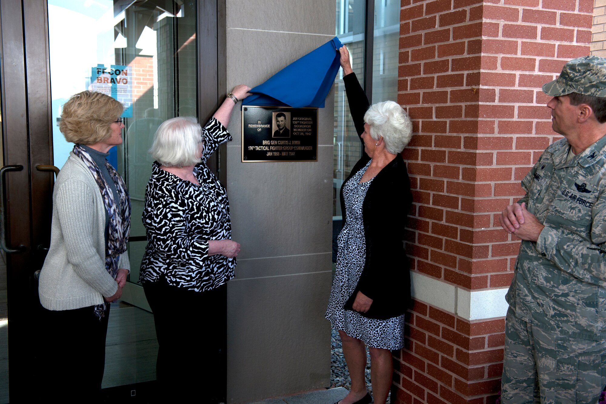 Ms. Sheila Austin, Ms. Laurie Irwin and Chief Master Sergeant (retired) Lisa Damon unveil the plaque in front of the 174th Attack Wing Headquarters building. The headquarters building was dedicated to their father the late Brigadier General Curtis J. Irwin in a ceremony held October 4, 2015. (New York Air National Guard photo by Senior Airman Duane Morgan/Released)