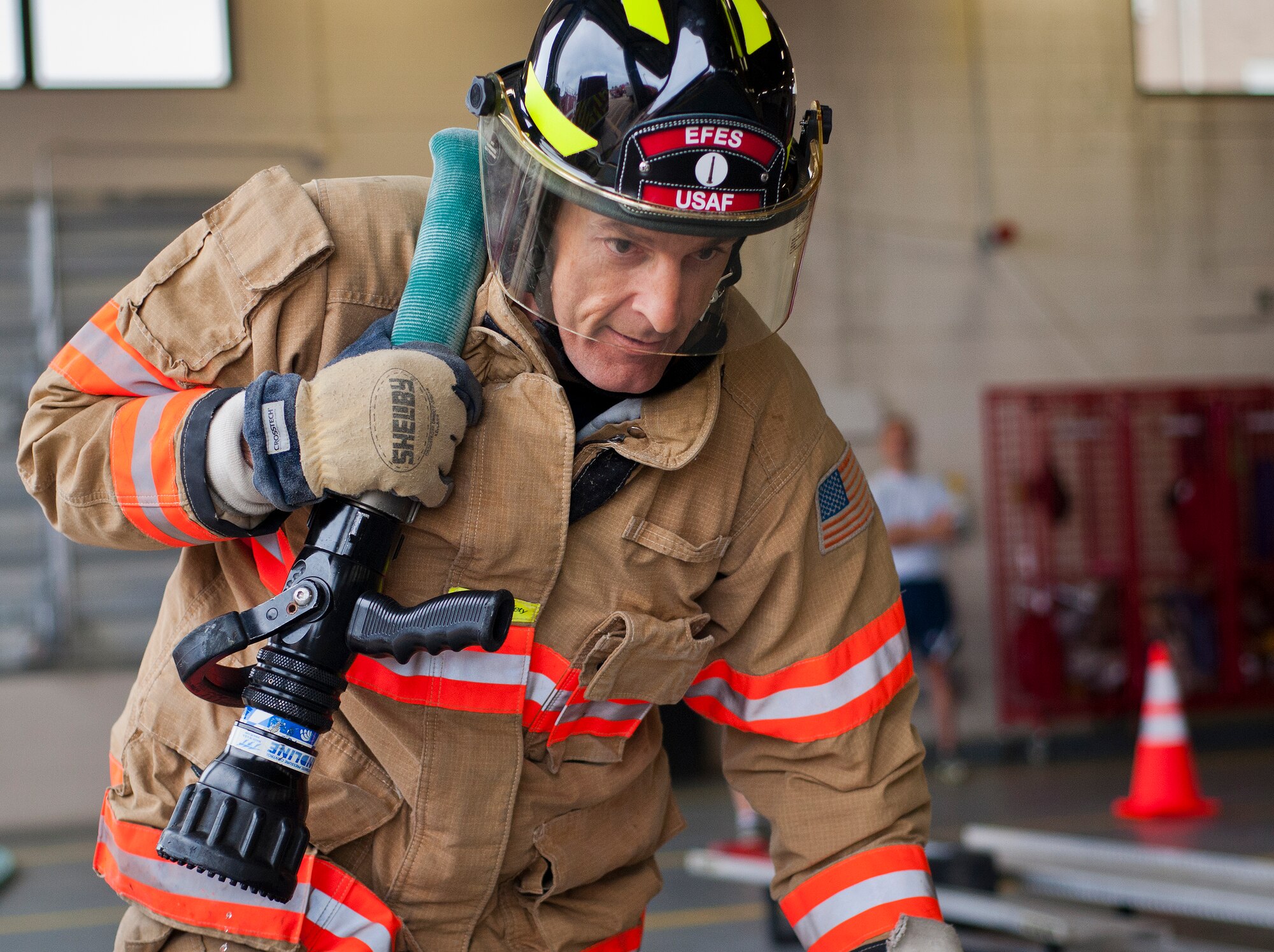 Col. Craig Johnson, 96th Civil Engineer Group commander, carries a fire hose during the sixth annual Fire Prevention Week Readiness Challenge Oct. 5 at Eglin Air Force Base, Fla.  Commanders, chiefs and colonels participated in the challenge that replicated common fitness tasks of base firefighters.  The challenge included hose dragging, ladder climbing, victim carry among others.  (U.S. Air Force photo/Samuel King Jr.)  