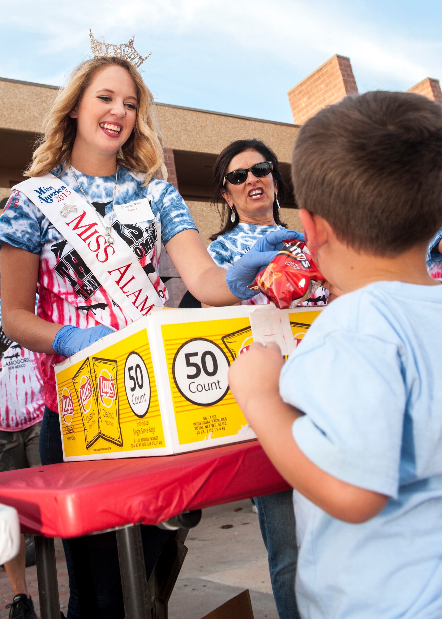 Raini O’Connor, 2015 Miss Alamogordo, and Margie Macias, New Mexico School for the Blind administrator, serve food to patrons at the annual Thanks Team Holloman event at Holloman Air Force Base, Oct. 2. Various members from the Alamogordo community volunteered to host this year’s event to show appreciation for Team Holloman. (U.S. Air Force photo by Airman 1st Class Randahl J. Jenson)  
