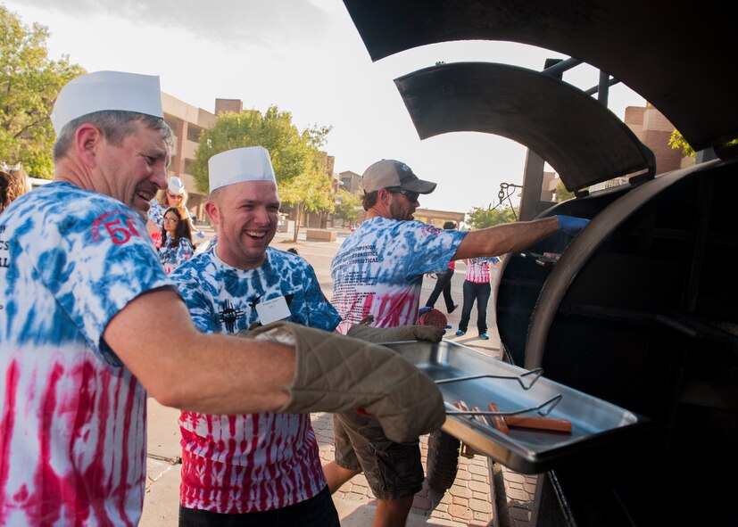 Dan McNett, the storeroom manager for the Shifting Sands dining facility at Holloman Air Force Base, Chris Preston, a barista at Starbucks®, and Bobby Curran, a lineman for P&M Power Company, grill hotdogs and hamburgers at the annual Thanks Team Holloman event at Holloman AFB, Oct. 2. Alamogordo community members volunteered at the event to show their appreciation by helping serve food to members of Team Holloman. (U.S. Air Force photo by Airman 1st Class Randahl J. Jenson) 