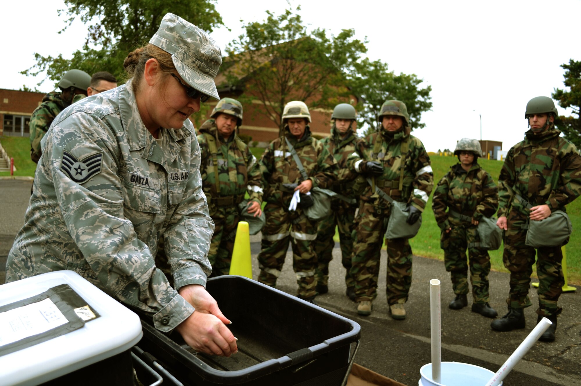 Staff Sgt. Alisa Garza, 111th Attack Wing’s base civil engineering squadron emergency manager, explains decontamination techniques and entry and exit into various zones during Chemical, Biological, Radiological, Nuclear and Explosives survival training Oct. 3, 2015, at Horsham Air Guard Station, Pennsylvania. Garza demonstrated the procedures to Guardsmen donning their Mission Oriented Protective Posture gear who had just finished training with the M-50 joint service general purpose mask. (U.S. Air Force photo by Tech. Sgt. Andria Allmond/Released)