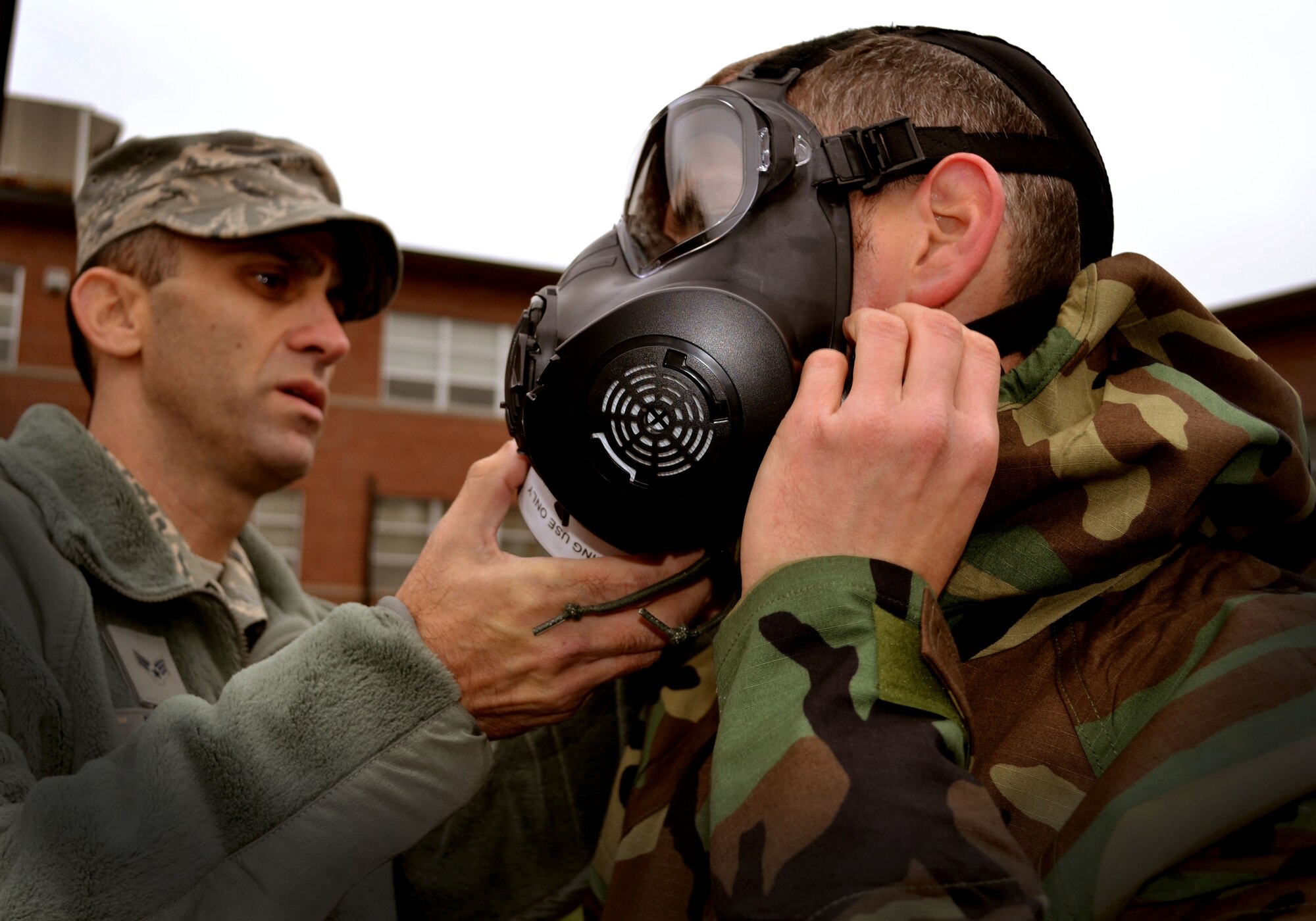 Senior Airman Christopher Feder, 111th Attack Wing’s base civil engineering squadron emergency manager, helps a 111th Attack Wing Guardsman with his M-50 joint service general purpose mask during Chemical, Biological, Radiological, Nuclear and Explosives survival training Oct. 3, 2015, at Horsham Air Guard Station, Pennsylvania. The 111th Attack Wing members involved in the CBRNE survival training also received Self-Aid and Buddy Care training. (U.S. Air Force photo by Tech. Sgt. Andria Allmond/Released) 