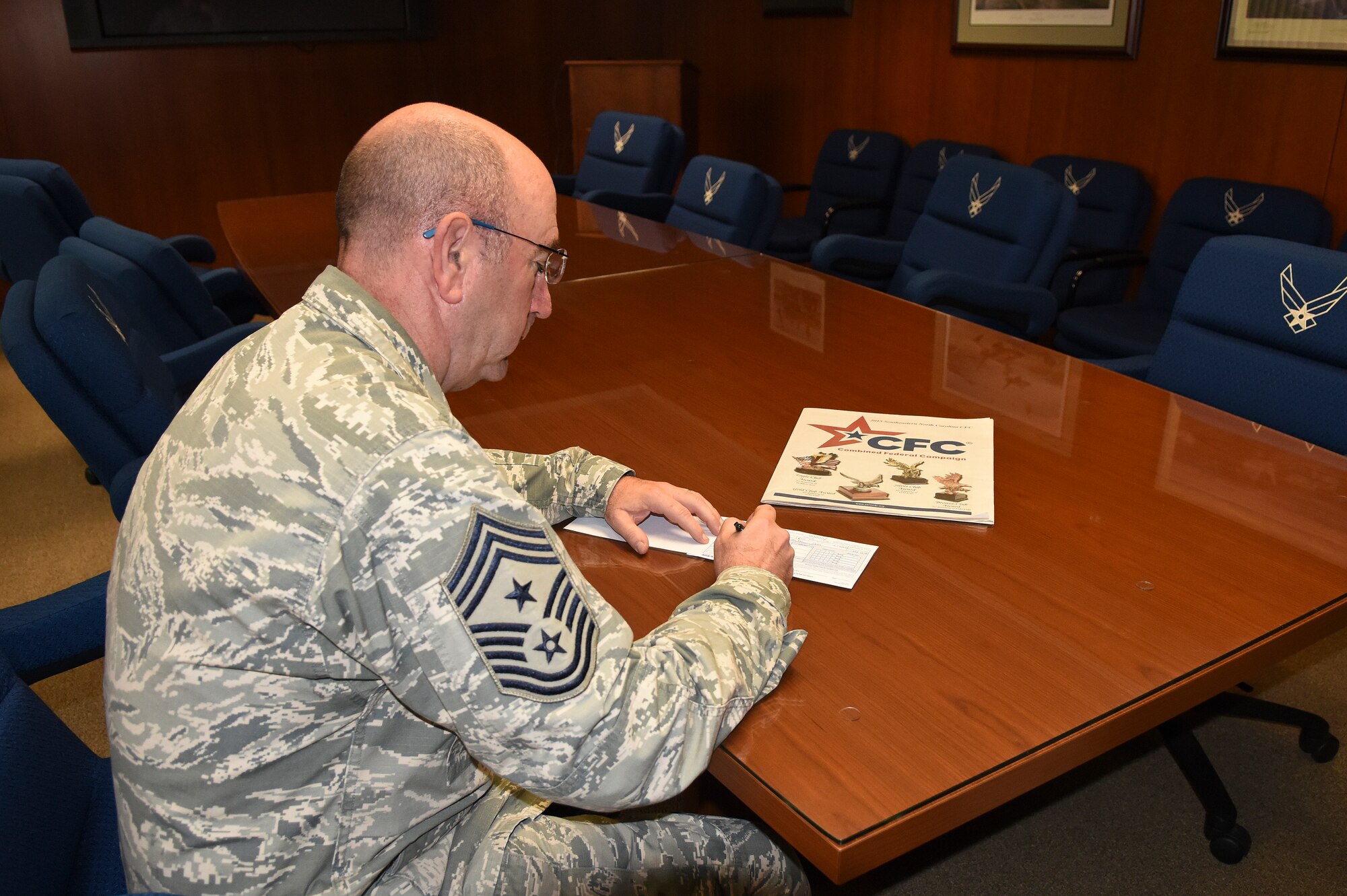 Chief Master Sgt. Jeffrey Craver, 4th Fighter Wing command chief, signs his pledge form to kick off the annual Combined Federal Campaign on Oct. 2, 2015, at Seymour Johnson Air Force Base, North Carolina. Wing leaders hope to raise more than $180,000 during this year’s campaign, which ends Nov. 2. (U.S. Air Force photo/Senior Airman Aaron J. Jenne)
