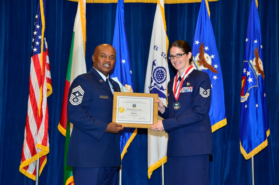 MCGHEE TYSON AIR NATIONAL GUARD BASE, Tenn. - Tech. Sgt. Danielle Gray, right, receives the Distinguished Graduate Award for NCO academy class 15-6 from  Chief Master Sgt. Anthony Whitehead, command Chief Master Sgt. for the Air National Guard Readiness Center, here, Sept. 30, 2015, at the I. G. Brown Training and Education Center. The distinguished graduate award is presented to students in the top 10 percent of the class. (U.S. Air National Guard photo by Master Sgt. Jerry D. Harlan/Released)