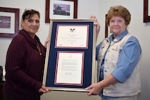 Anna Richar (left), Horsham Air Guard Station’s Airman & Family Readiness Center program manager, holds the President’s Volunteer Service Award alongside Jenny Papas, Friends of the Family Readiness Group, a 501(c)(3) organization,  president Oct. 4, 2015 at the Wing headquarters building, Horsham Air Guard Station, Pennsylvania. Richar earned the accolades for her work with veterans and military families in 2014. (U.S. Air National Guard photo by Master Sgt. Chris Botzum/Released).

