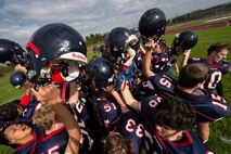 The Bitburg Barons celebrate their victory over the SHAPE Spartans after the Bitburg Middle High School homecoming football game at Bitburg Annex, Germany, Oct. 3, 2015. The Bitburg Barons defeated the SHAPE Spartans 32-7. (U.S. Air Force photo by Staff Sgt. Christopher Ruano/Released)