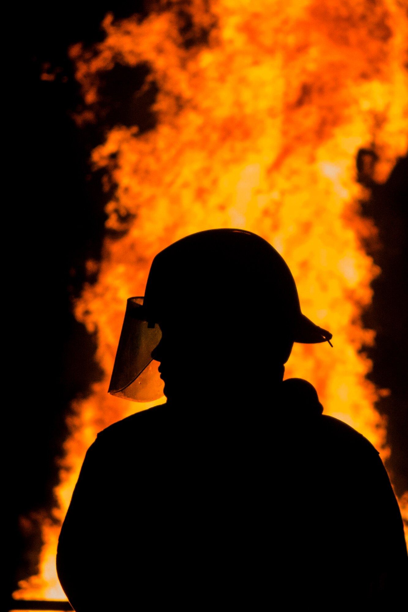 A 52nd Civil Engineer Squadron firefighter monitors a bonfire after a Homecoming parade at Spangdahlem Air Base, Germany, Oct. 2, 2015. The bonfire lasted a couple hours and was the last event of the night. (U.S. Air Force photo by Airman 1st Class Luke Kitterman/Released)  