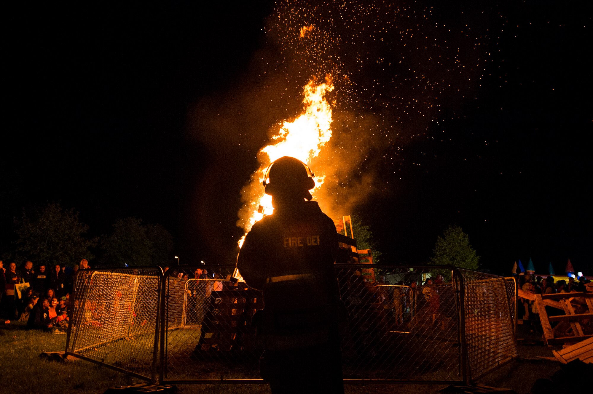 A 52nd Civil Engineer Squadron firefighter monitors a bonfire after a Homecoming parade at Spangdahlem Air Base, Germany, Oct. 2, 2015. Having a bonfire after the parade is a tradition for Homecoming weekend. (U.S. Air Force photo by Airman 1st Class Luke Kitterman/Released)