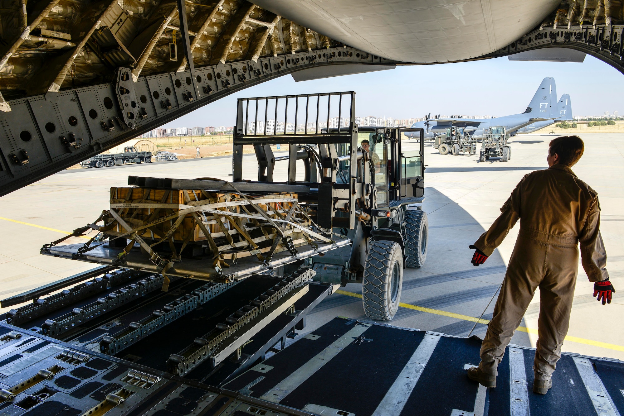 Senior Airman Ashley Igulo, 14th Airlift Squadron loadmaster, guides Airman 1st Class Christopher McDade, 435th Contingency Response Squadron air transportation journeyman, as he unloads cargo from a C-17 Globemaster III Sept. 28, 2015, at Diyarbakir Air Base, Turkey. The equipment will being used in support of U.S. Air Forces Central Command personnel recovery mission for Operation Inherent Resolve. (U.S. Air Force photo by Airman 1st Class Cory W. Bush/Released)

