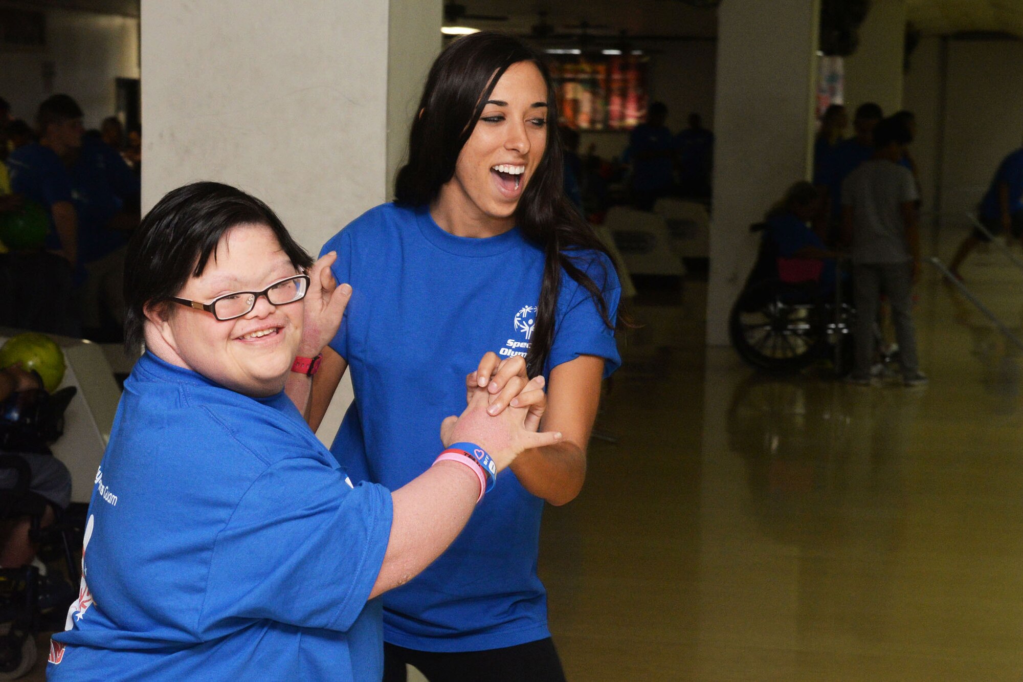 Staff Sgt. Kimberly Chroniak, 36th Maintenance Squadron, celebrates with a Special Olympics Guam athlete Oct. 3, 2015, at a bowling center in Tamuning, Guam. Service members dedicated eight weeks to coach participants for the event which included 125 athletes with intellectual disabilities. (U.S. Air Force photo by Senior Airman Joshua Smoot/Released)
