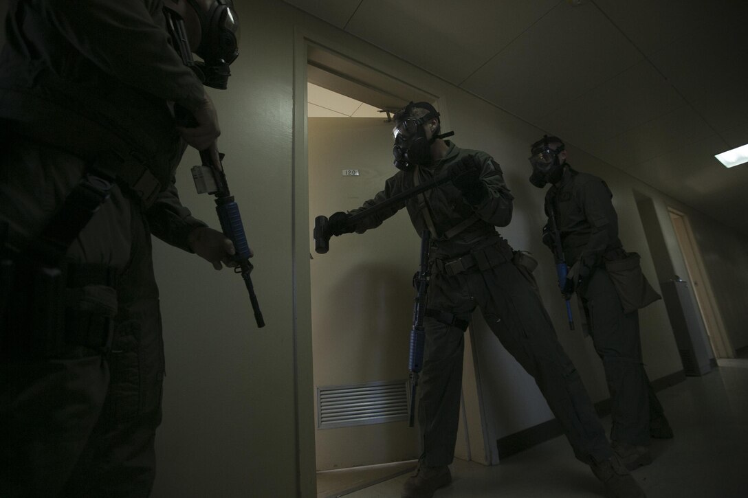The Special Reaction Team breaches a barricaded door Sept. 23 during an active shooter exercise as part of Exercise Constant Vigilance 2015 aboard Camp Foster. SRT Marines swept through the building, clearing each floor room by room, ensuring no other threats were present before arriving at the shooter’s barricade. SRT breached the barricade, detained the shooter and removed the hostage from the room. The Special Reaction Team responds to trouble calls such as active shooters with hostages in the same way the civilian special law enforcement teams act, according to Staff Sgt. Brandon Price, the section chief of the Special Reaction Team with the Provost Marshal’s Office Headquarters and Support Battalion, Marine Corps Installations Pacific-Marine Corps Base Camp Butler, Japan.