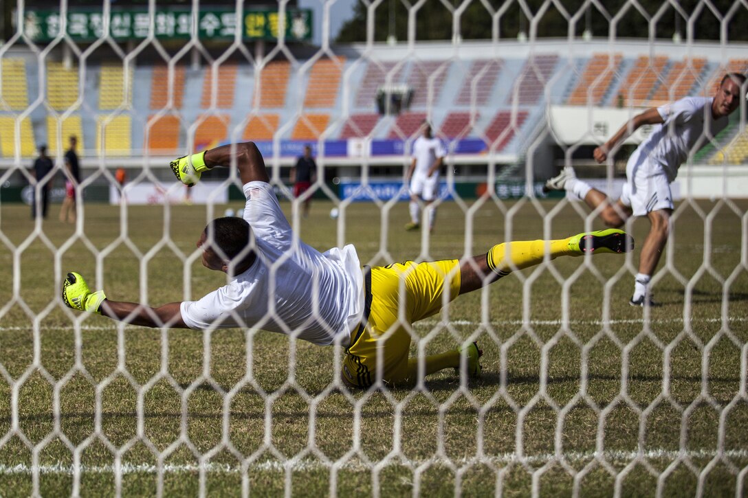 Miguel Cebrero dives to save the ball during a warm up drill before the U.S. men's soccer team's match against Qatar at the 6th CISM Military World Games in Mungyeong, South Korea, Oct. 4, 2015. The CISM World Games allows athletes from more then 100 countries to come together in friendship through sports. U.S. Marine Corps photo by Cpl. Jordan Gilbert