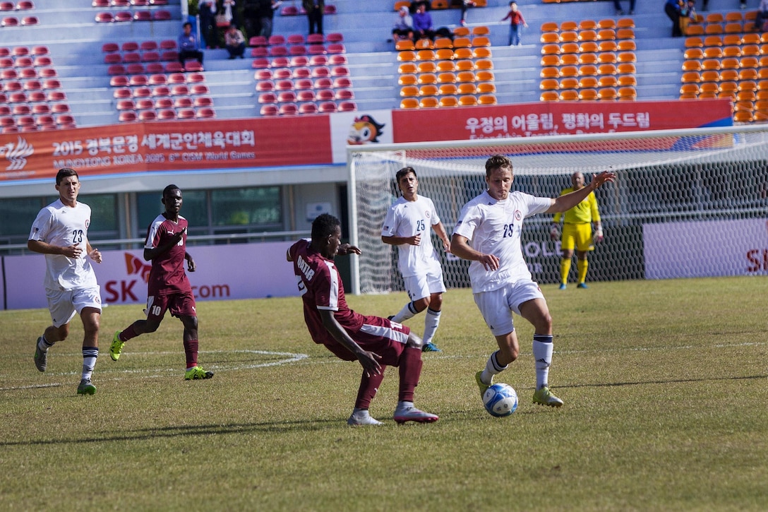 U.S. men's soccer team player Caleb Downey, right, dribbles the ball away from the Qatar men's soccer team during the 6th CISM Military World Games in Mungyeong, South Korea, Oct. 4, 2015. U.S. Marine Corps photo by Sgt. Ashley Cano 