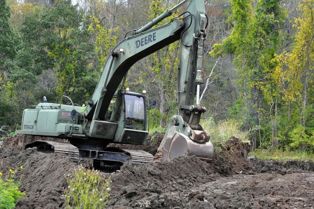 A soldier operates a backhoe to clear space near Normanskill Creek in Albany, N.Y., Friday, Oct. 2, 2015 as part of New York's preparations for the possible landfall of Hurricane Joaquin. The soldier is assigned to the New York Army National Guard's 204th Engineer Battalion. New York Army National Guard photo by Sgt. Major Corine Lombardo 