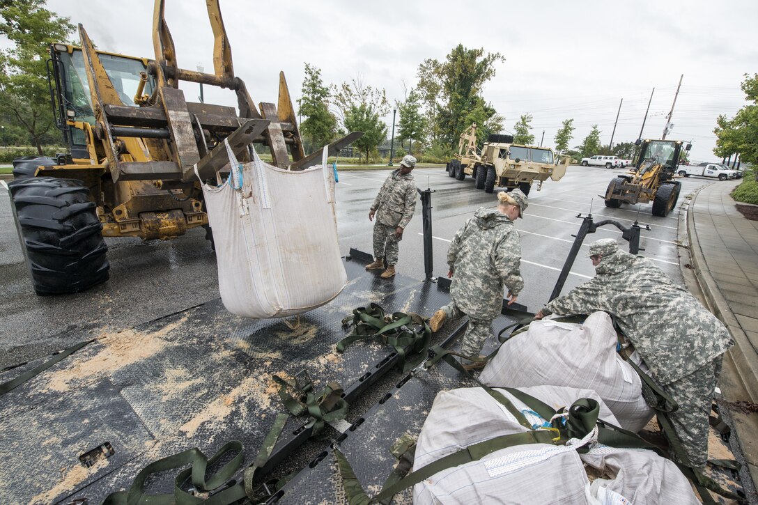 South Carolina Army National Guard soldiers deliver sandbags to the Columbia Riverfront Canal in an effort to repair the canal's breached levee in Columbia, S.C., Oct. 5, 2015. The soldiers are assigned to Company A, 218th Brigade Support Battalion. South Carolina National Guard photo by Air Force Tech. Sgt. Jorge Intriago