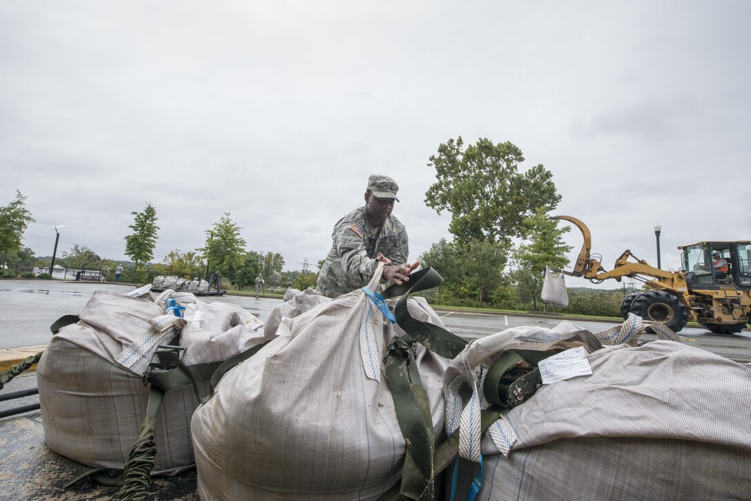 Army 1st Lt. Courtney Jones delivers sandbags to the Columbia Riverfront Canal in Columbia, S.C., Oct. 5, 2015. Jones is a quartermaster executive officer with Company A, 218th Brigade Support Battalion, South Carolina Army National Guard. South Carolina National Guard photo by Air Force Tech. Sgt. Jorge Intriago