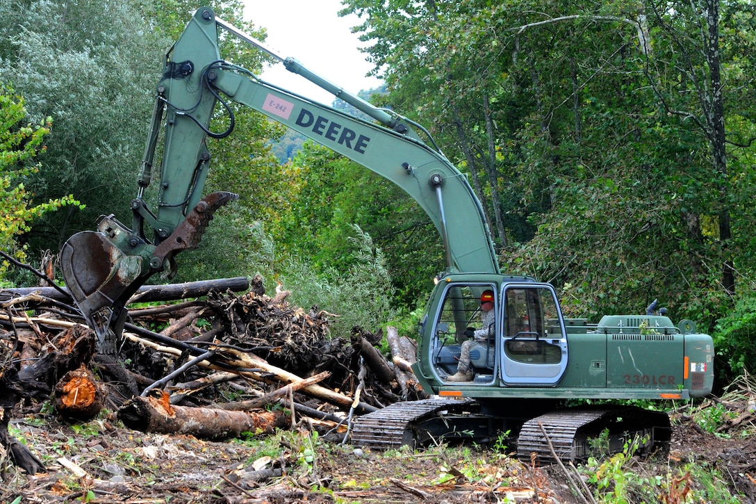 Army Sgt. Jim Searfoss operates a hydraulic excavator to remove debris from Esopus Creek as part of the cleanup mission in preparation for Hurricane Joaquin, in Shandanken, N.Y., Oct. 2, 2015. Searfoss is a heavy duty equipment operator assigned to the New York Army National Guard’s 827th Engineer Company. New York Army National Guard photo by Sgt. Michael Davis