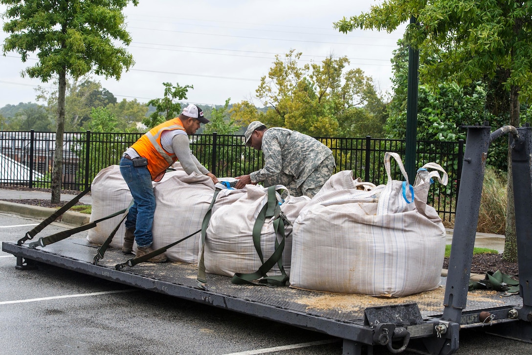 Army 1st Lt. Courtney Jones and a local contractor help deliver sandbags to the Columbia Riverfront Canal in Columbia, S.C., Oct. 5, 2015. Jones is a quartermaster executive officer assigned to Company A, 218th Brigade Support Battalion. U.S. Air National Guard photo by Tech. Sgt. Jorge Intriago