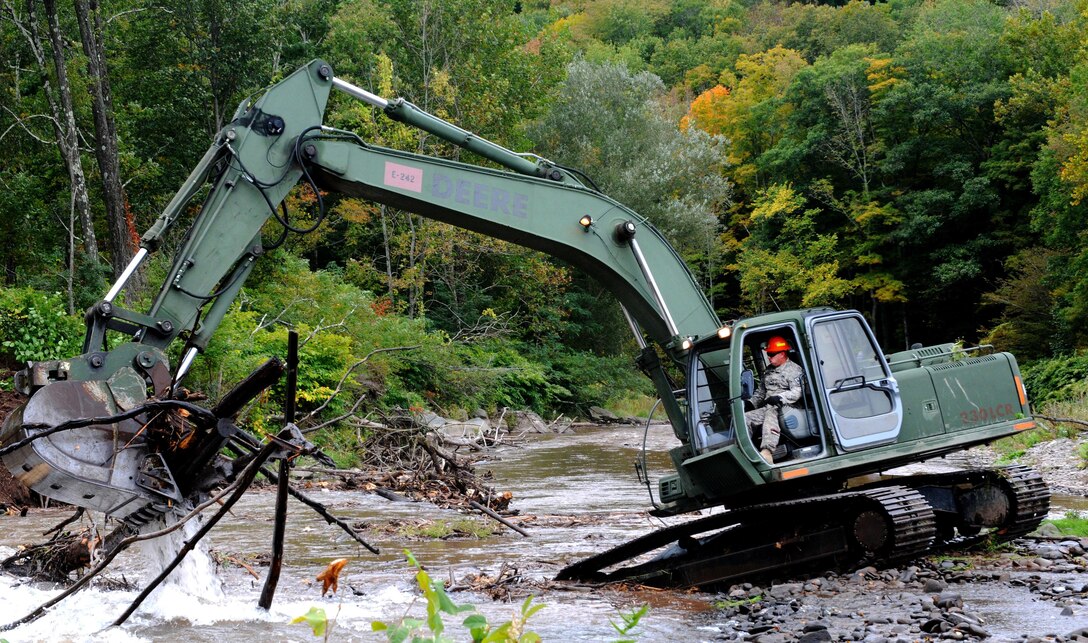 Army Sgt. Jim Searfoss operates a hydraulic excavator to remove debris from Esopus Creek as part of the cleanup mission in preparation for Hurricane Joaquin, in Shandanken, N.Y., Oct. 2, 2015. Searfoss is a heavy duty equipment operator assigned to the New York Army National Guard’s 827th Engineer Company. New York Army National Guard photo by Sgt. Michael Davis