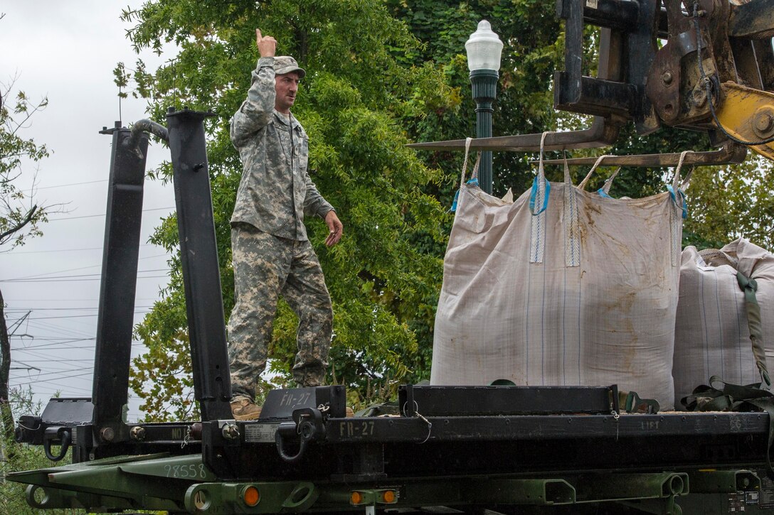 Army Spc. Nathan Saalfield helps deliver sandbags to the Columbia Riverfront Canal in Columbia, S.C., Oct. 5, 2015. Saalfield is assigned to Company A, 218th Brigade Support Battalion. South Carolina National Guard photo by Air Force Tech. Sgt. Jorge Intriago