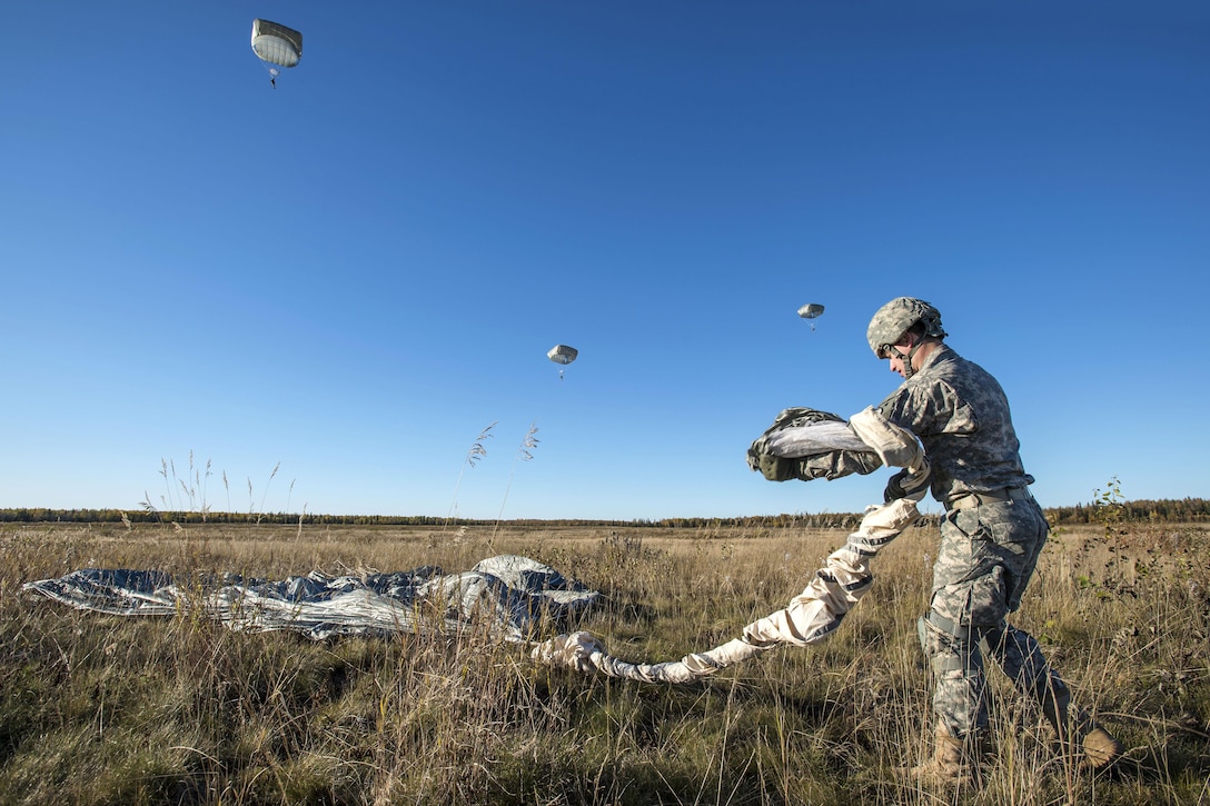 Army Spc. Conner Cota recovers his parachute after conducting a helicopter jump on Malemute drop zone, Joint Base Elmendorf-Richardson, Alaska, Sept. 24, 2015. Cota is assigned to Company E, 6th Brigade Engineer Battalion. U.S. Air Force photo by Alejandro Pena