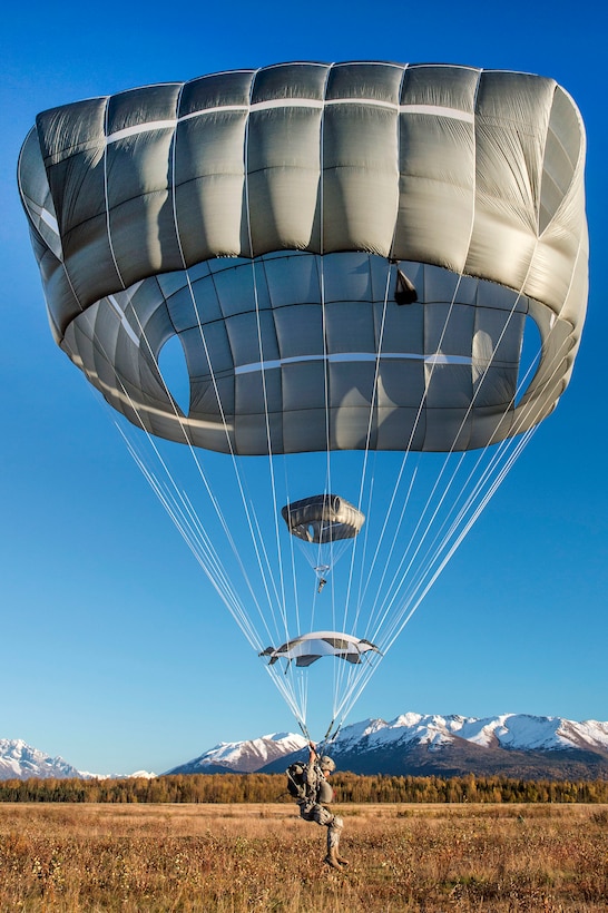 Paratroopers descend while conducting a helicopter jump over Malemute drop zone, Joint Base Elmendorf-Richardson, Alaska, Sept. 24, 2015. U.S. Air Force photo by Alejandro Pena