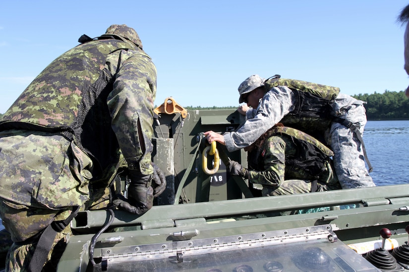 Sgt. 1st Class John Reyes of the Knoxville, Tenn., 1-100th Engineer Battalion helps Canadian military engineer students unhook and deploy a mobile floating bridge (MFB) during a training exercise at the Canadian Forces School of Military Engineering (CFSME) at Canadian Forces Base Gagetown in New Brunswick, Canada, as part of an instructor exchange initiative between the U.S. and the CFSME, spearheaded by 1st Brigade Engineers out of Fort Leonard Wood, Mo.