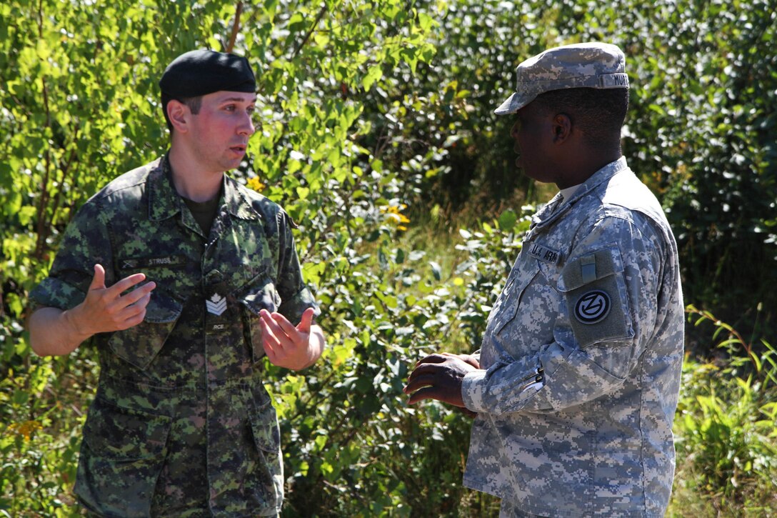 Sgt. 1st Class Oniel Murray, 1st Engineer Brigade, 102nd Training Division, 80th Training Command, discusses the differences in teaching techniques with his Canadian counterpart, Canadian Armed Forces Sgt. Corey Struss at the Canadian Forces School of Military Engineering at Canadian Forces Base Gagetown in New Brunswick, Canada, as part of an instructor exchange initiative between the U.S. and the CFSME, spearheaded by 1st Brigade Engineers.
