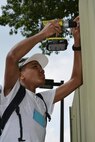 Caleb Strother makes minor repairs to the fence around a garbage bin on the grounds of the Bethesda, Md., Fisher House, which provides free temporary lodging to military veterans and family members while their loved ones receive care at nearby Walter Reed National Military Medical Center. Strother, whose father, Woodson, is a sergeant first class assigned to the 94th Training Division, and nine other members of the 80th Training Command (TASS) Teen Council participated in a joint meeting with members of the 412th Theater Engineer Command and the 75th Training Command teen councils in Alexandria, Va., July 27-31, 2015. The council members helped beautify the Fisher House grounds as part of their community service requirement.