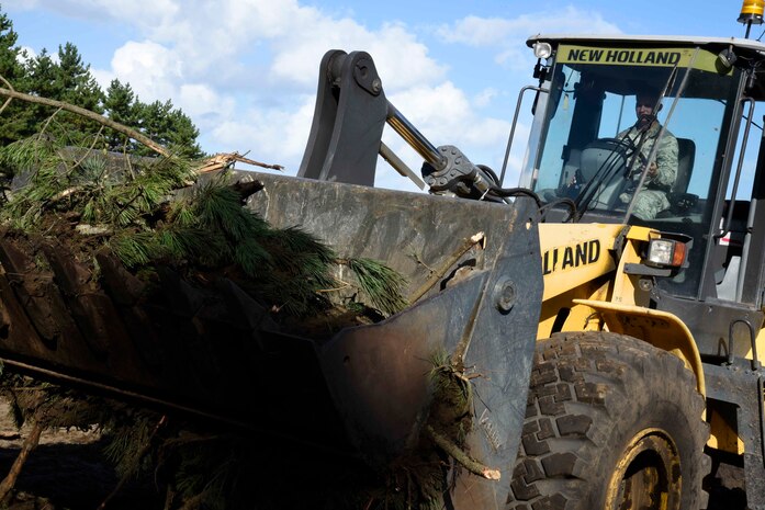 U.S. Air Force Airman Jeffrey Waldron, 35th Civil Engineer Squadron pavement and construction equipment apprentice, removes tree branches with a front-end loader at Draughon Range, Japan, Sept. 29, 2015. Construction on the new Combat Arms Training and Maintenance facility began Aug. 20 and is slated to be complete near the end of 2016. (U.S. Air Force Airman 1st Class Jordyn Fetter/Released) 