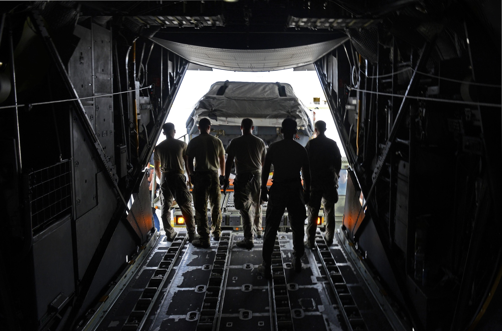 A team of MC-130 Combat Talon II loadmasters assigned to the 1st Special Operations Squadron stand ready to receive a load carrier approaching the aircraft during an exercise Sept. 18, 2015, at Andersen Air Force Base, Guam. The MC-130H was part of a dissimilar formation with an MC-130J that completed a Maritime Craft Aerial Delivery System airdrop.  This was the first time an MC-130J Commando II completed the MCADS airdrop in the Pacific.  (U.S. Air Force photo by Staff Sgt. Alexander Riedel)
