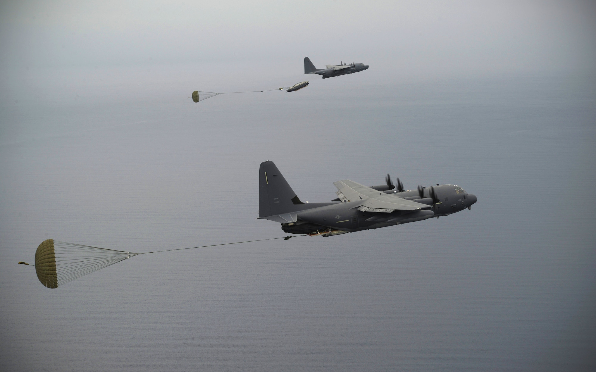 A U.S. Air Force MC-130J and MC-130H crew drop a watercraft and supplies during an exercise Sept. 19, 2015, over the Pacific Ocean.  This was the first time an MC-130J Commando II completed the Maritime Craft Aerial Delivery System airdrop in the Pacific. (U.S. Air Force photo by Airman 1st Class Alexa Ann Henderson)