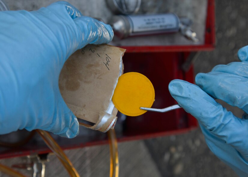 Senior Airman Daniel Shelly, 374th Logistics Readiness Squadron fuels management flight fuels laboratory supervisor, uses an in-line sampler to collect fuel for use in a particulate contamination test at Yokota Air Base, Japan, Oct. 1, 2015. This test guarantees the functional integrity of the refueling unit's filtration system. (U.S. Air Force photo by Senior Airman David Owsianka/Released)