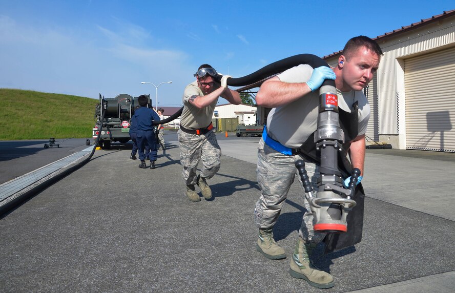 Members of the 374th Logistics Readiness Squadron fuels management flight pull a hose for a daily inspection at Yokota Air Base, Japan, Oct. 1, 2015. All refueling units must be inspected daily to ensure the safest and highest quality fuel is issued to the aircraft. (U.S. Air Force photo by Senior Airman David Owsianka/Released)